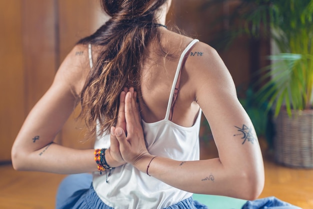 Mujer de yoga haciendo pose de oración inversa o pose de pingüino en el estudio Pashchima Namaskarasana o Viparita Namaskarasana