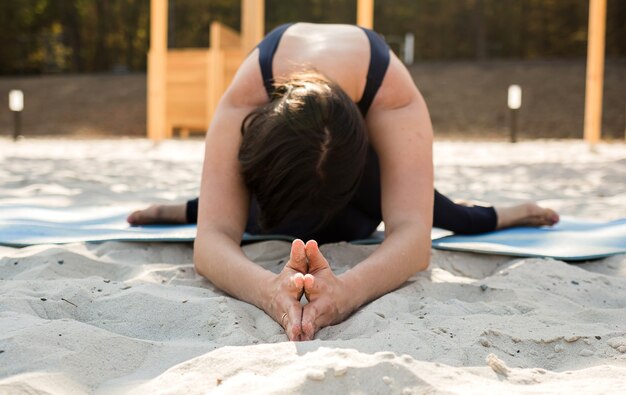 Una mujer de yoga realiza en la playa.