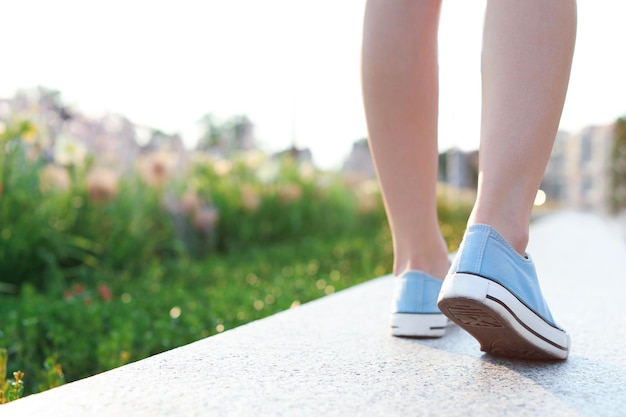 Mujer en zapatillas con estilo caminando al aire libre closeup Moda urbana