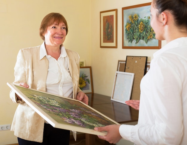 Mujeres adultas mirando la imagen en la galería de arte