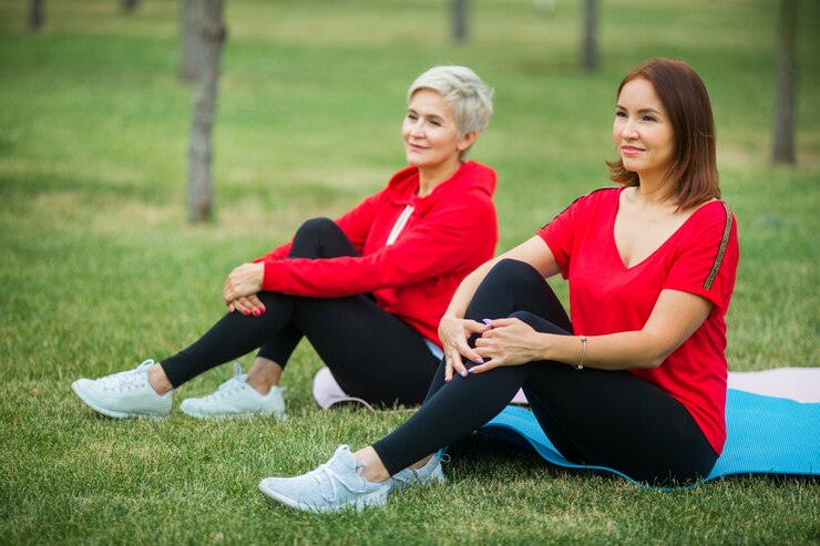 Mujeres adultas en ropa deportiva haciendo ejercicio en el parque