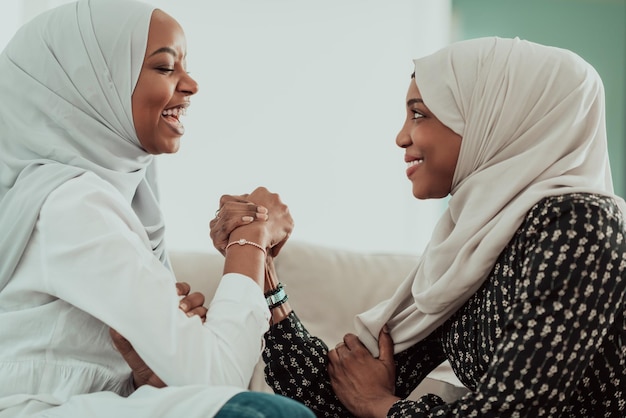 Las mujeres africanas luchan con los brazos concepto de conflicto, desacuerdo y confrontación usando ropa islámica tradicional de hiyab. Enfoque selectivo. foto de alta calidad