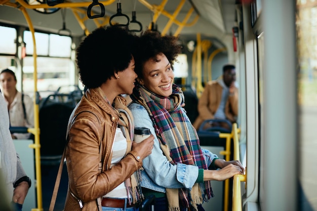 Mujeres afroamericanas felices disfrutando mientras viajan en autobús