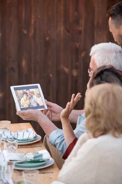 Una de las mujeres agitando la mano a la joven pareja en la pantalla de la tableta