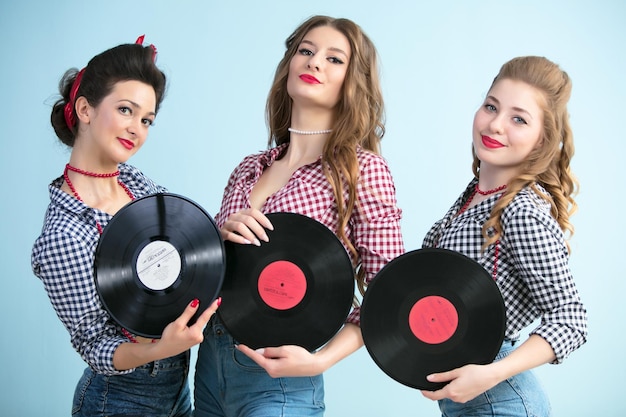 Mujeres al estilo de los años cincuenta con discos de vinilo