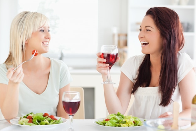 Mujeres alegres bebiendo vino