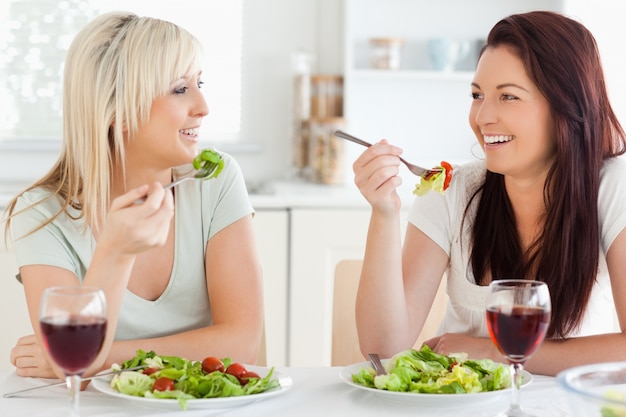 Mujeres alegres comiendo ensalada