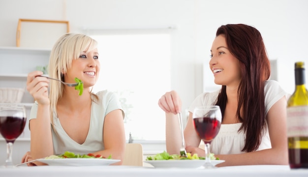 Mujeres alegres comiendo ensalada