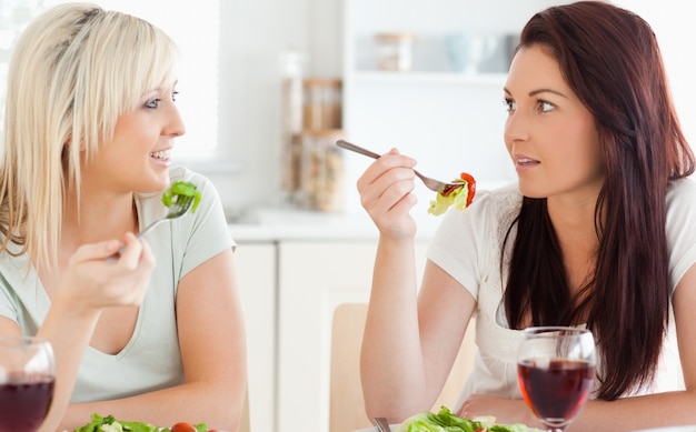 Mujeres alegres comiendo ensalada