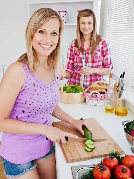 Mujeres alegres que cocinan juntas en casa