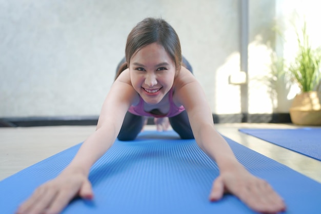 Mujeres alegres relajándose durante una sesión de ejercicios de yoga