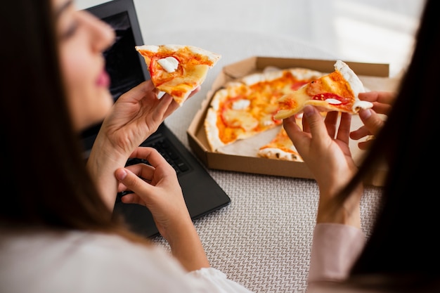 Foto mujeres de alto ángulo comiendo pizza deliciosa