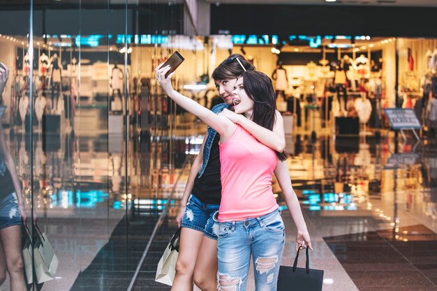 Foto mujeres amigas mientras compran con paquetes y compran juntos