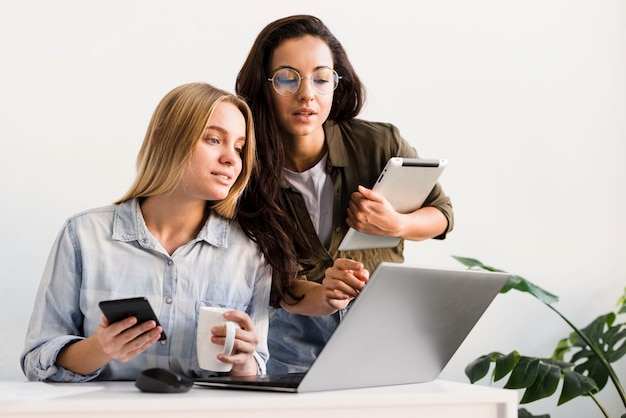 Foto mujeres de ángulo bajo en la oficina