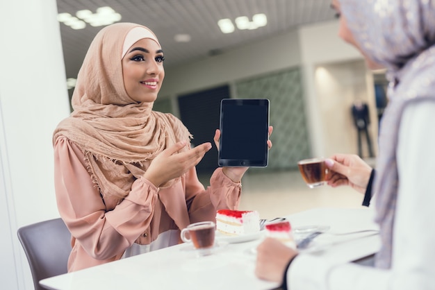 Mujeres árabes jóvenes sentadas en un café en un moderno centro comercial