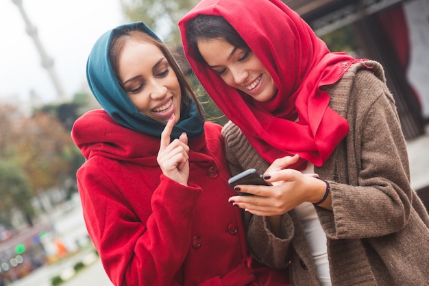 Mujeres árabes con velo usando un teléfono inteligente en Estambul