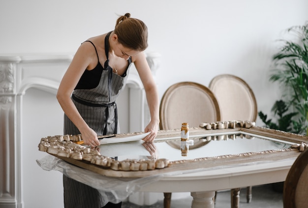 Mujeres artesanas manos trabajando en un gran marco de madera