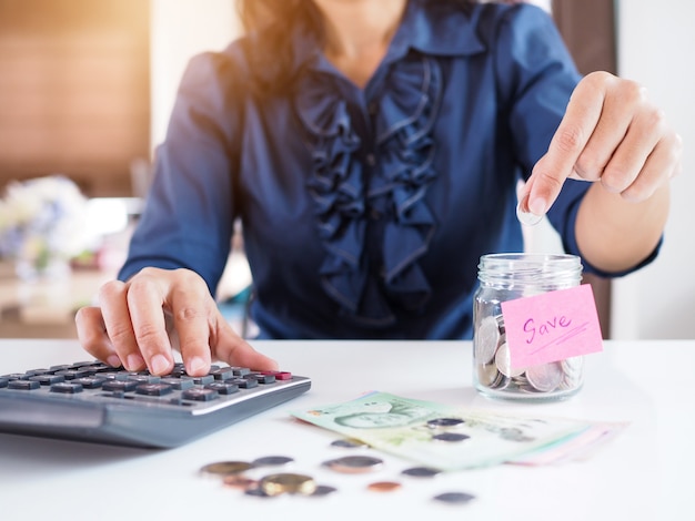 Las mujeres asiáticas ahorran dinero con recoger monedas en botellas de vidrio.