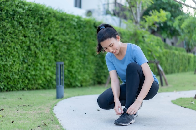 Mujeres asiáticas atarse los zapatos antes de salir a correr en Sathorn Park