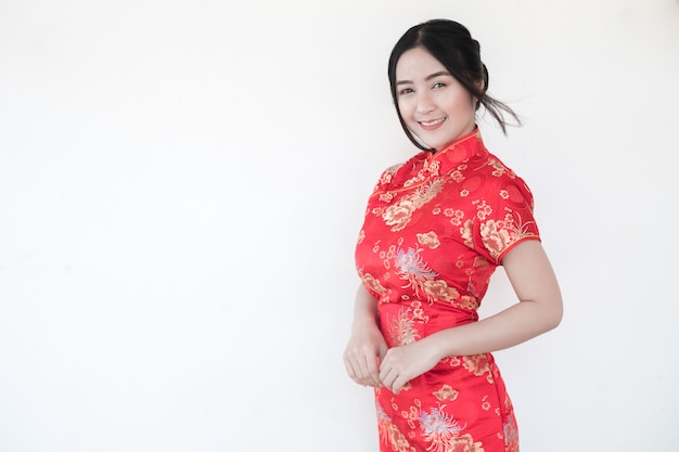 Mujeres asiáticas en cheongsam chino tradicional con un gesto de felicitaciones.