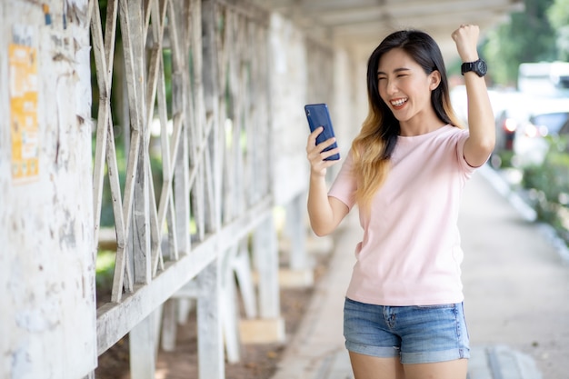 Las mujeres asiáticas se enfrentan a trabajos a través de teléfonos móviles.