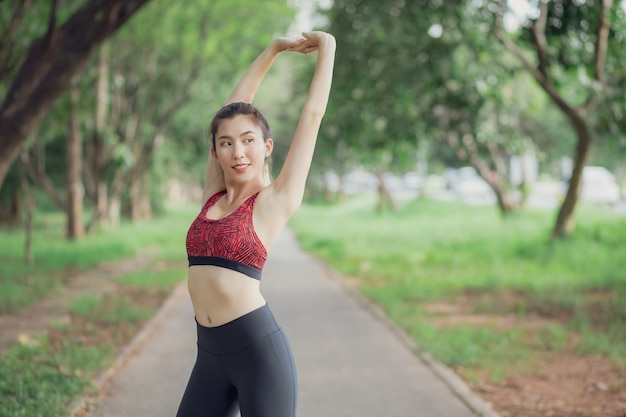 Las mujeres asiáticas escuchan música durante un entrenamiento en el parque.