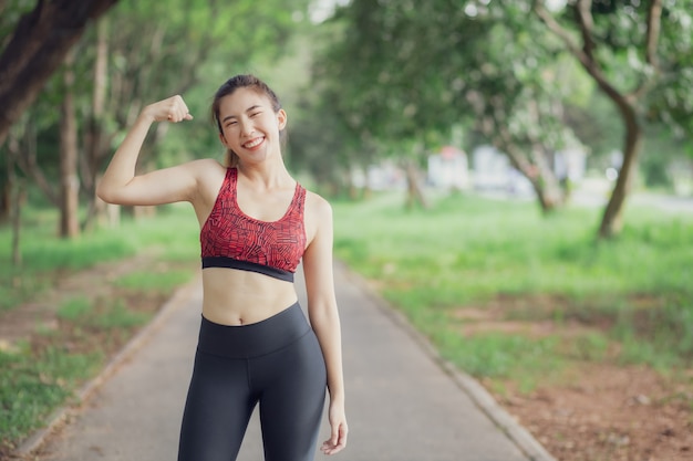 Las mujeres asiáticas escuchan música durante un entrenamiento en el parque.