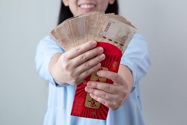 Las mujeres asiáticas están contentas de recibir mucho dinero extra de los sobres rojos.