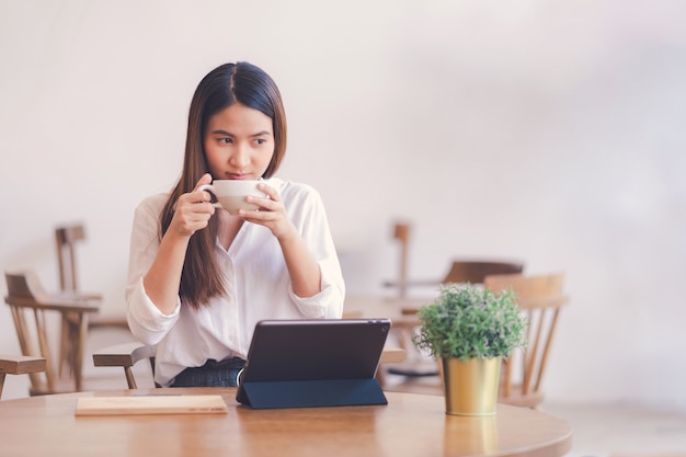 Las mujeres asiáticas están tomando café con leche.