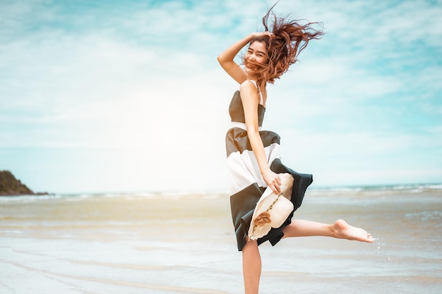 Las mujeres asiáticas felices con sombrero de explotación corriendo y saltan gozosamente disfrutan de la vida en las vacaciones en la playa. playa, verano, liftstyle, estado de ánimo positivo, viajes, concepto de relax.