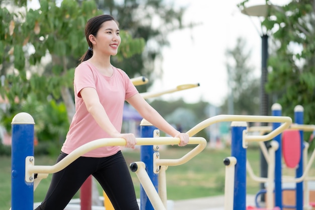 Las mujeres asiáticas hacen ejercicio en el parque, usan el equipo para hacer ejercicio y mantenerse en forma, saludables y en buena forma.