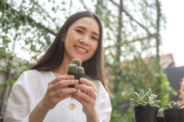 Las mujeres asiáticas jardinería casera cactus en el jardín de su casa
