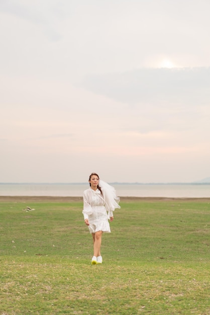 Mujeres asiáticas jóvenes felices vestidas de novia con velo