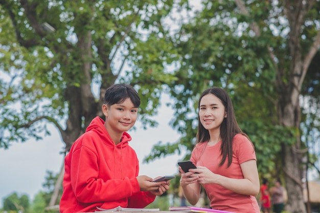 Las mujeres asiáticas con Lady boy LGBT están utilizando tecnología en línea de clase de estudio de aprendizaje de búsqueda de teléfonos inteligentes móviles, concepto de educación de regreso a la escuela