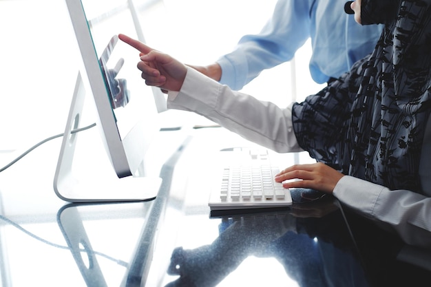 Las mujeres asiáticas y musulmanas sonrientes son colegas y operadoras de centros de llamadas o secretarias con auriculares