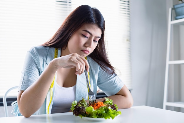 Mujeres asiáticas con el objetivo de perder peso pero cansadas de comer ensalada de verduras