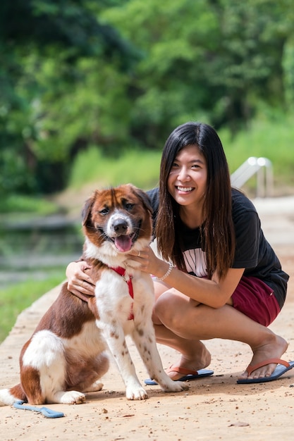Las mujeres asiáticas con perro de raza mixta en marrón