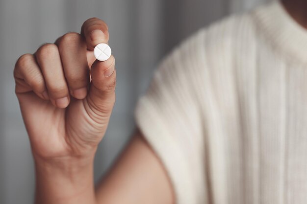 Mujeres asiáticas con una píldora blanca en la mano para el concepto médico y de atención médica