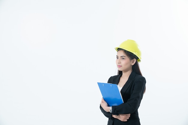 Mujeres asiáticas que inspeccionan y trabajan y que sostienen planos y la comprobación del portapapeles aislado