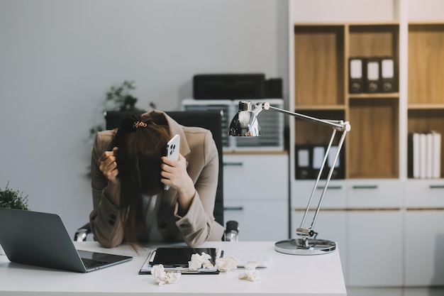 Mujeres asiáticas sentadas en una oficina con estrés y fatiga ocular retrato cansado de triste infeliz cansado frustrado decepcionado dama que sufre de migraña sentada en la mesa concepto de trabajador enfermo