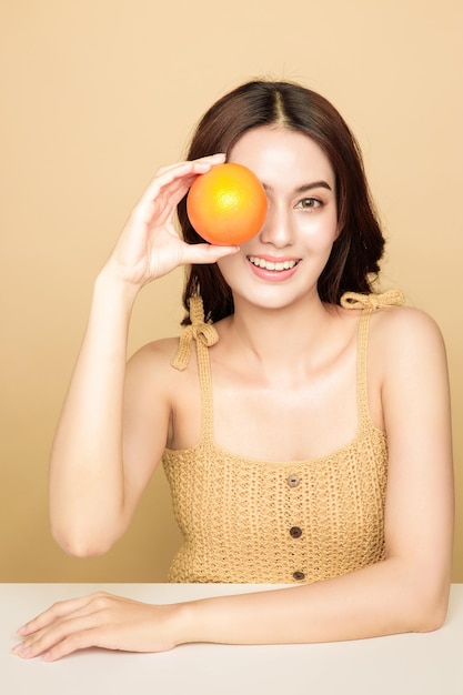 Las mujeres asiáticas son felices con una piel perfecta, limpia y saludable y un hermoso cabello largo y castaño con naranja