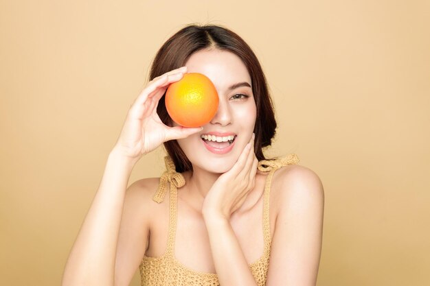 Las mujeres asiáticas son felices con una piel perfecta, limpia y saludable y un hermoso cabello largo y castaño con naranja