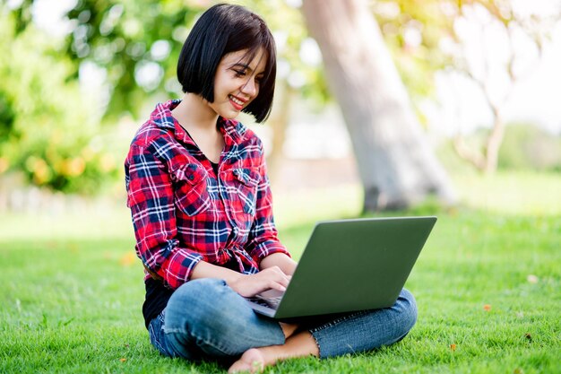 Las mujeres asiáticas sonríen felices y el portátil trabaja en línea comunicación en línea mensajería en línea