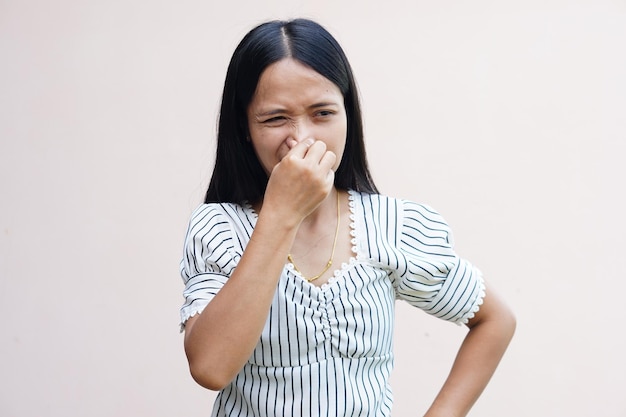 Mujeres asiáticas se tapan la nariz con las manos porque huelen mal