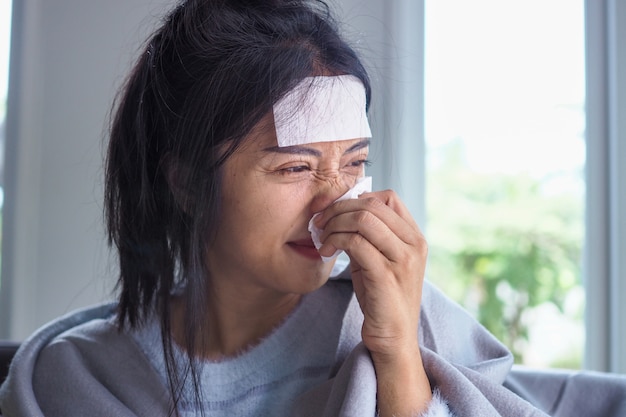 Las mujeres asiáticas tienen fiebre alta y secreción nasal. gente enferma