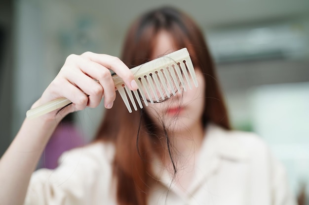 Las mujeres asiáticas tienen problemas con la pérdida de cabello largo y se adhieren al cepillo de peine.