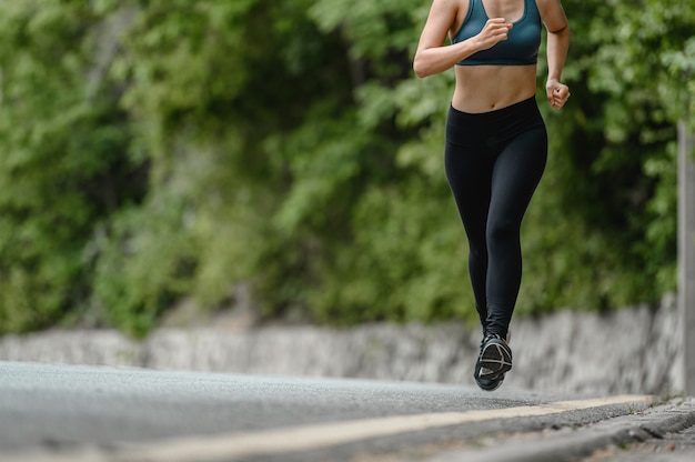 Mujeres asiáticas trotar en la carretera cerca de las montañas. Ejercicio, fitness, entrenamiento, ejercicio de gimnasio, estilo de vida y concepto saludable.