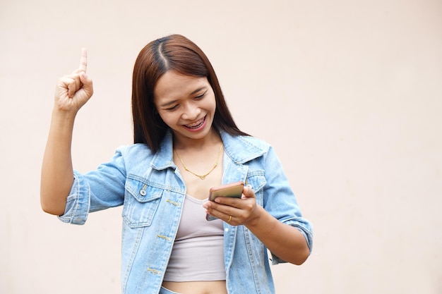 Las mujeres asiáticas usan felizmente sus teléfonos porque los resultados operativos son más rentables