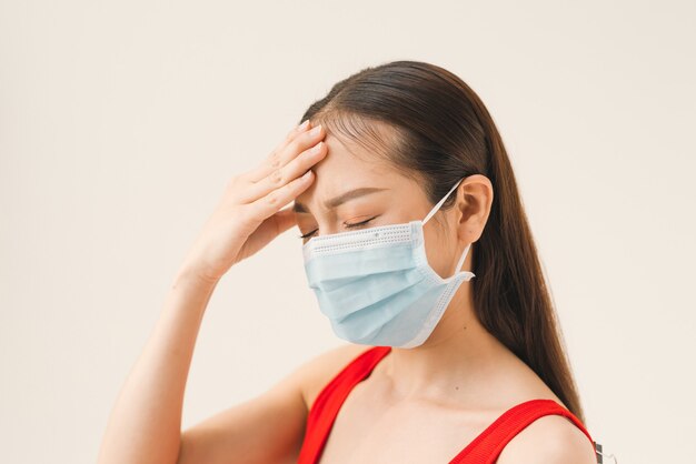 Las mujeres asiáticas usan máscaras para proteger la enfermedad y el dolor de cabeza de un virus sobre fondo blanco.