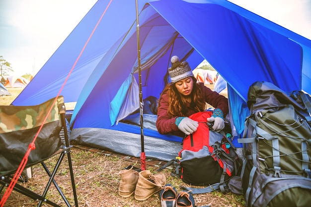 Las mujeres asiáticas viajan a relajarse en las vacaciones. acampar en la montaña. despierta, siéntate en una tienda de campaña. Tailandia